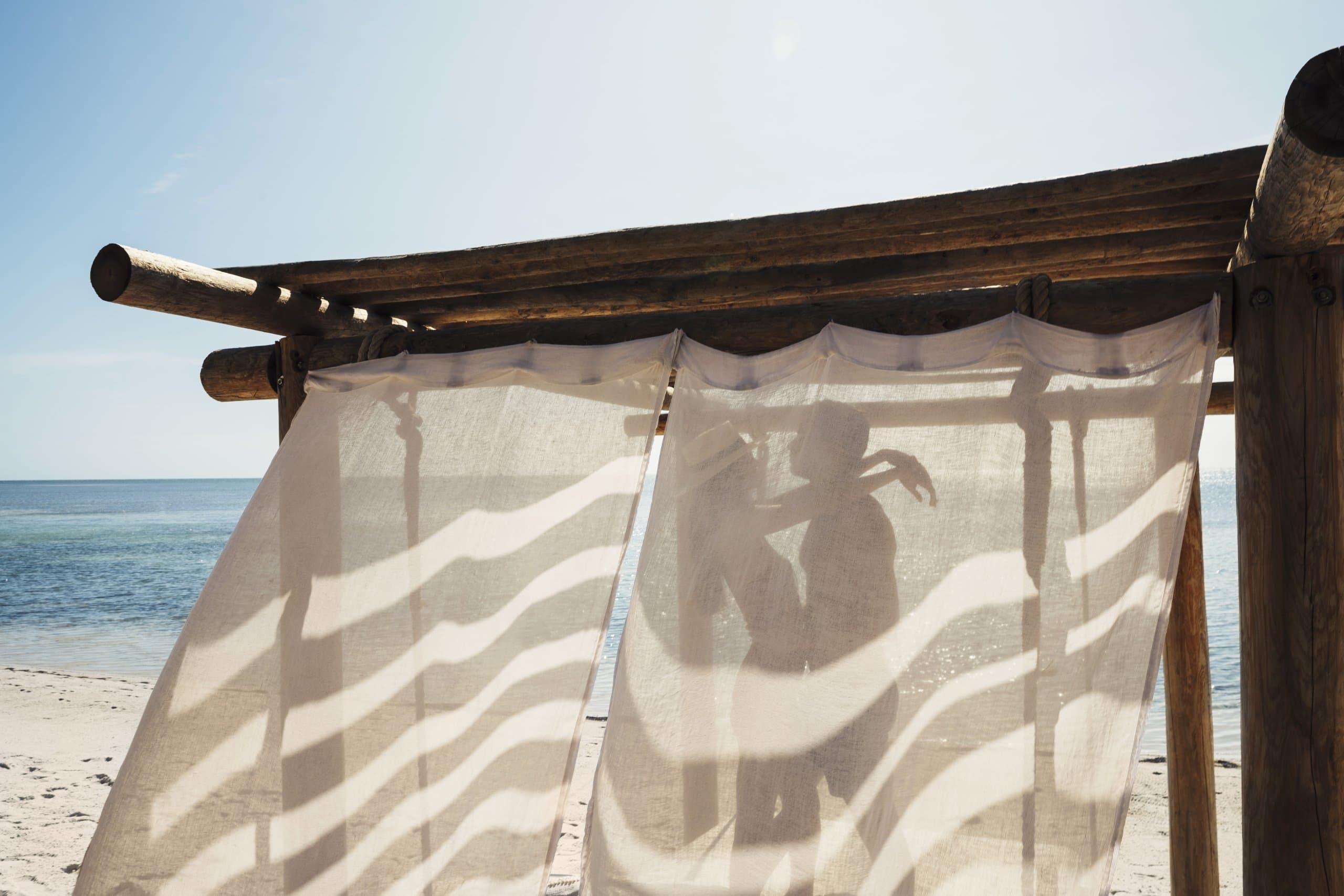 A couple embracing in a beach cabana at Little Palm Island Resort.