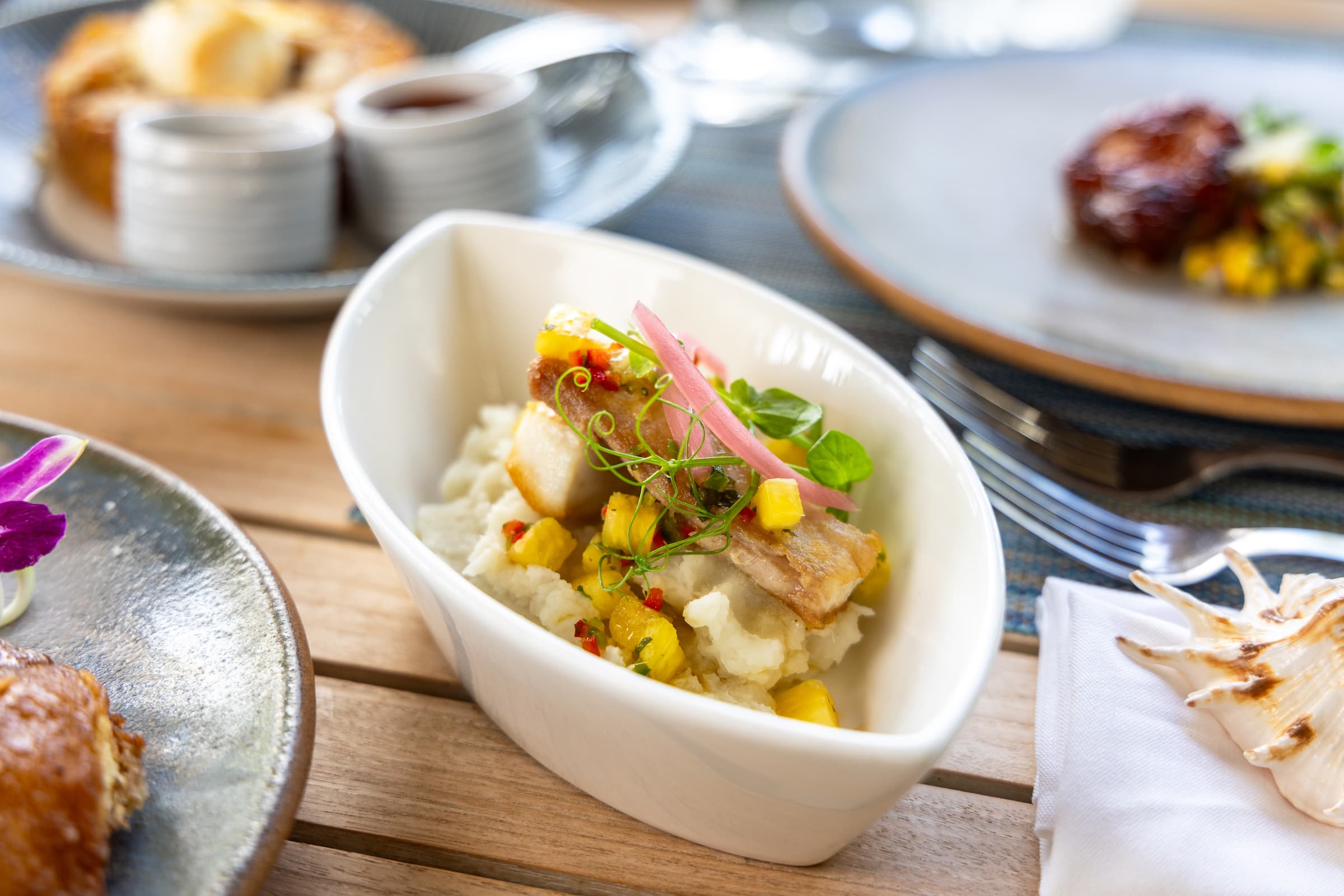 Tuna poke nachos featuring fresh tuna, pineapple, and jalapenos, served in a boat shaped bowl at Little Palm Island Resort