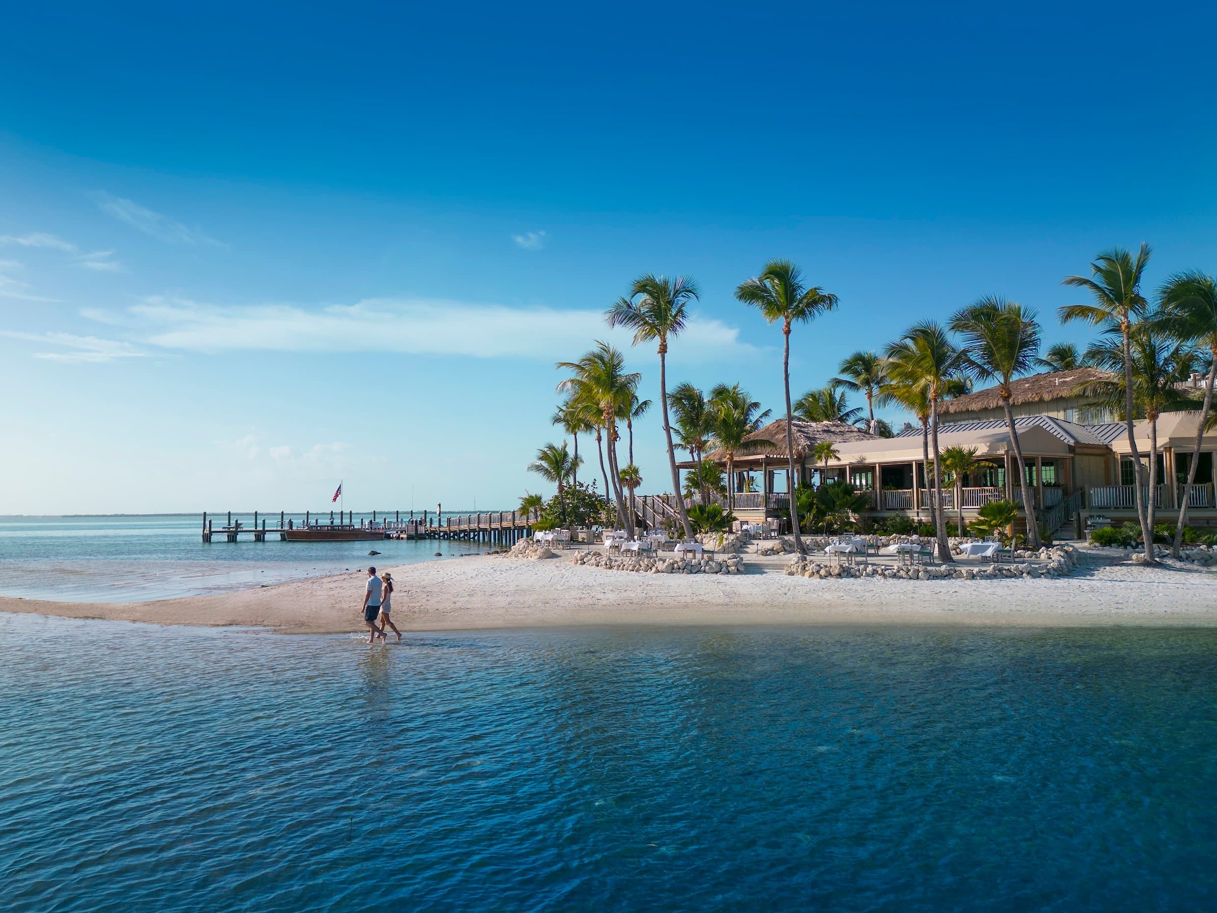 Couple walking along the beach on Little Palm Island