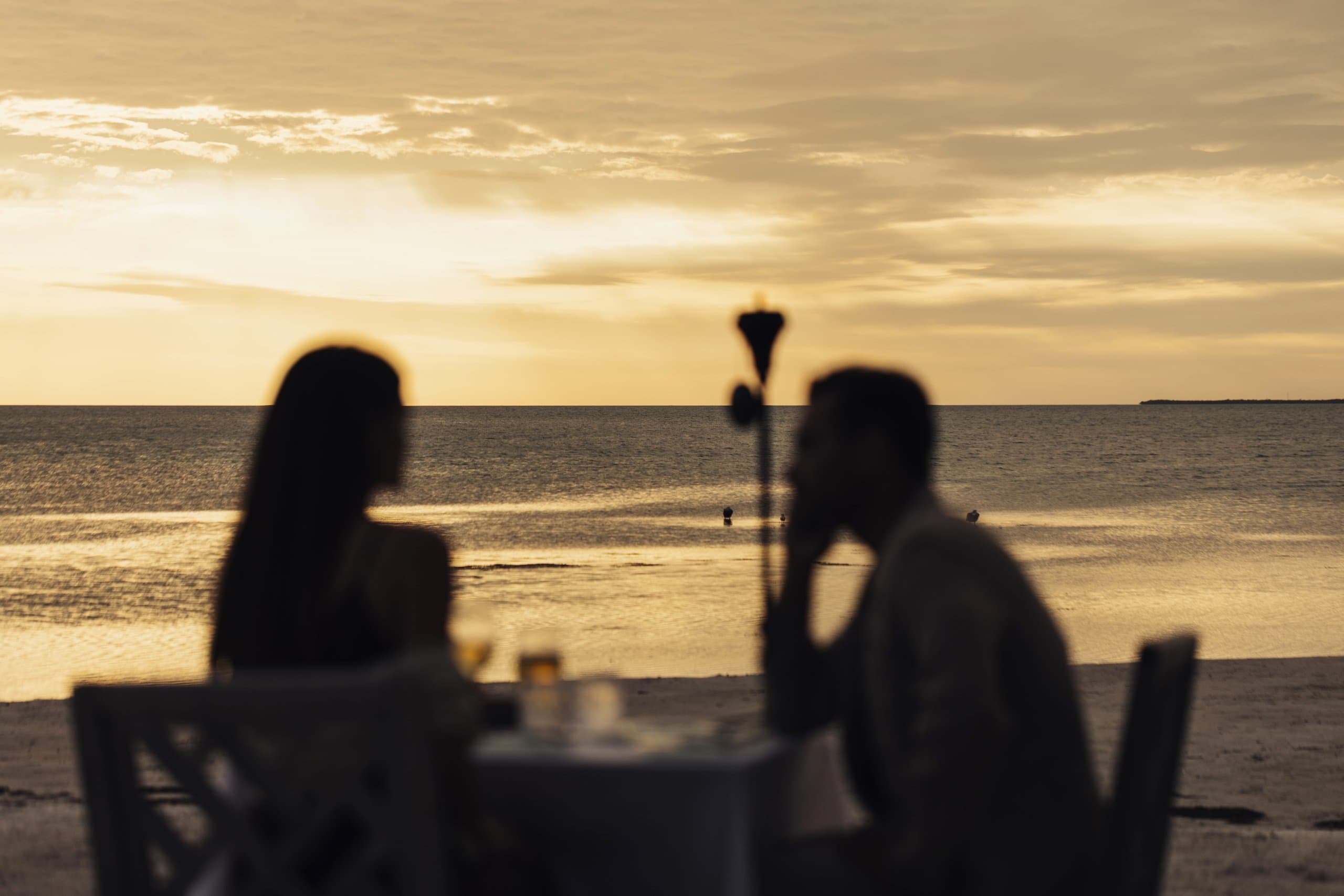 A couple dining intimately on the beach at sunset at Little Palm Island Resort & Spa.