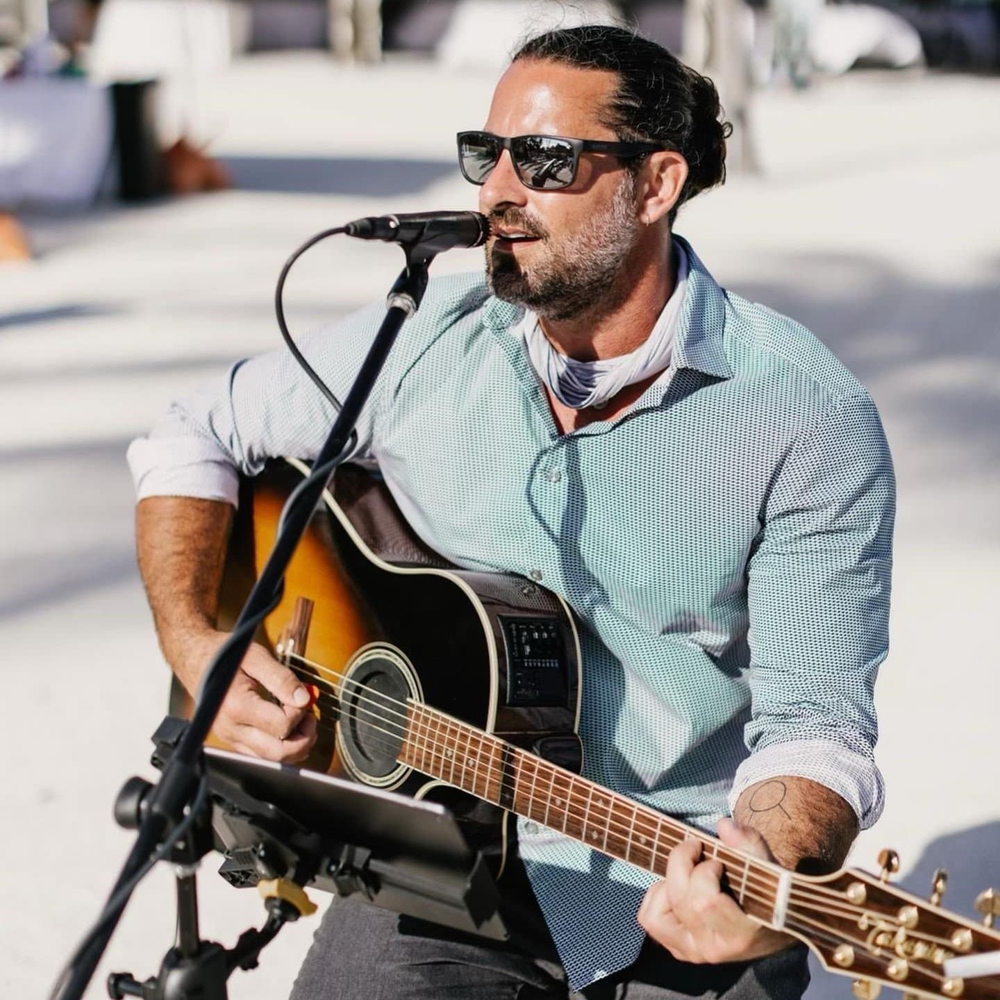 Rusty Lemmon plays guitar and performs at an event.