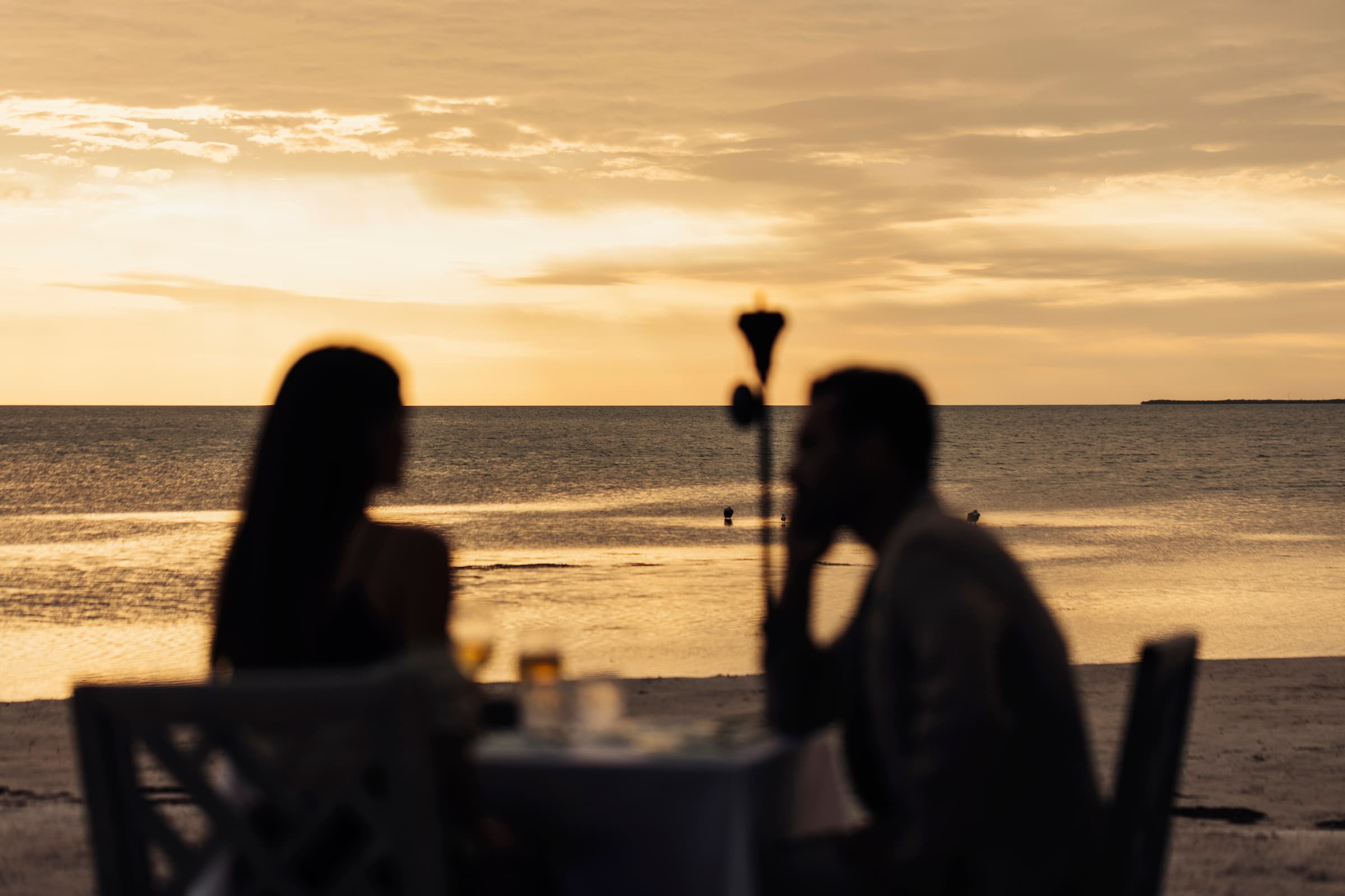A couple on the beach having a private meal at Little Palm Island Resort