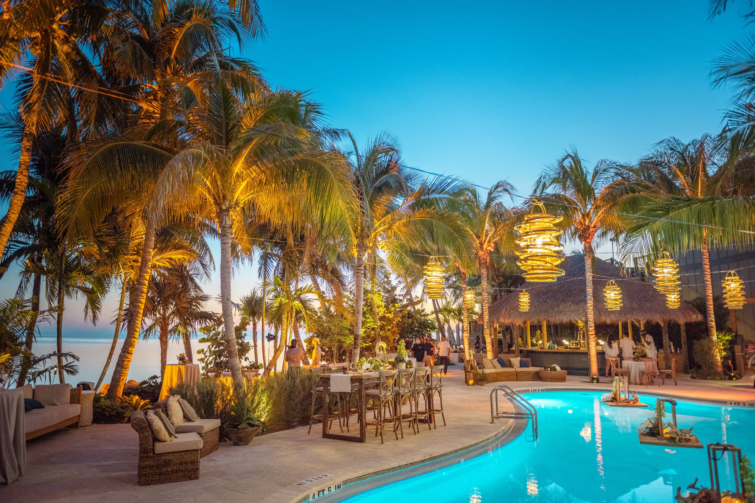 Little Palm Island Resort's oceanfront outdoor swimming pool and tiki bar at sunset