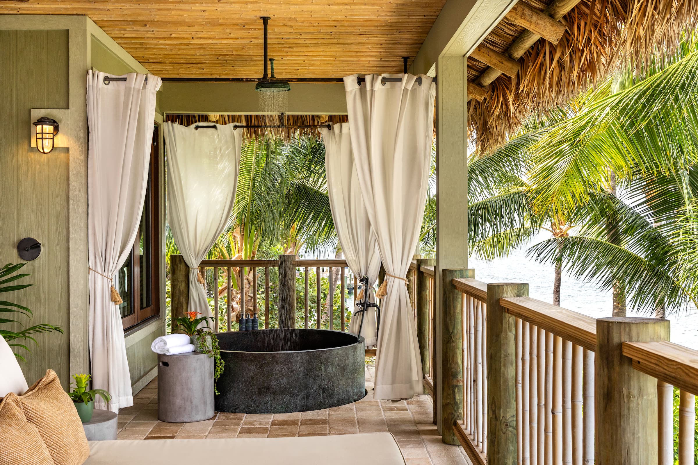 A furnished terrace with outdoor copper soaking tub in Little Palm Island Resort's Premier Suite