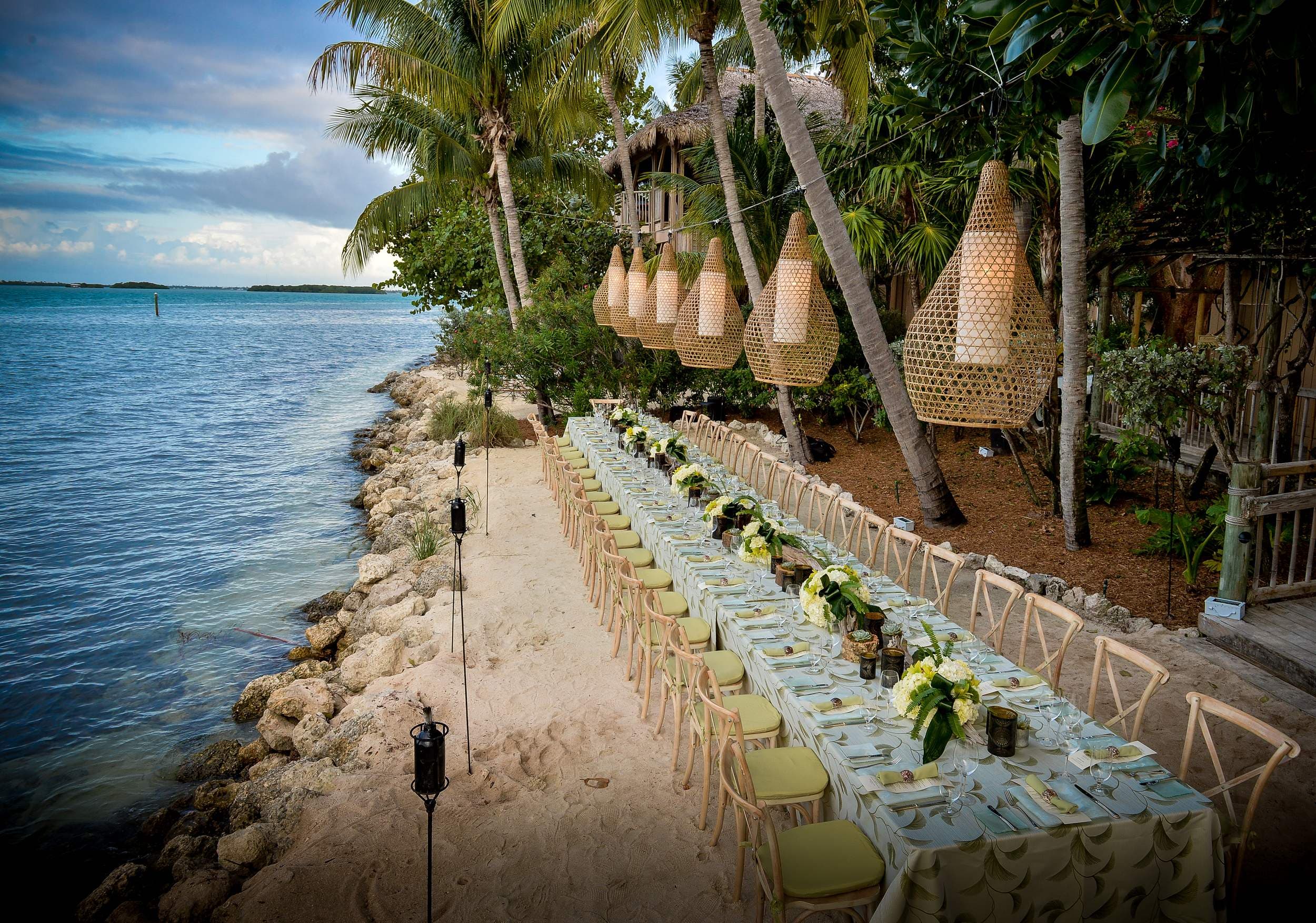 Little Palm Island beachfront wedding reception table with rattan lanterns overlooking the Florida Keys water