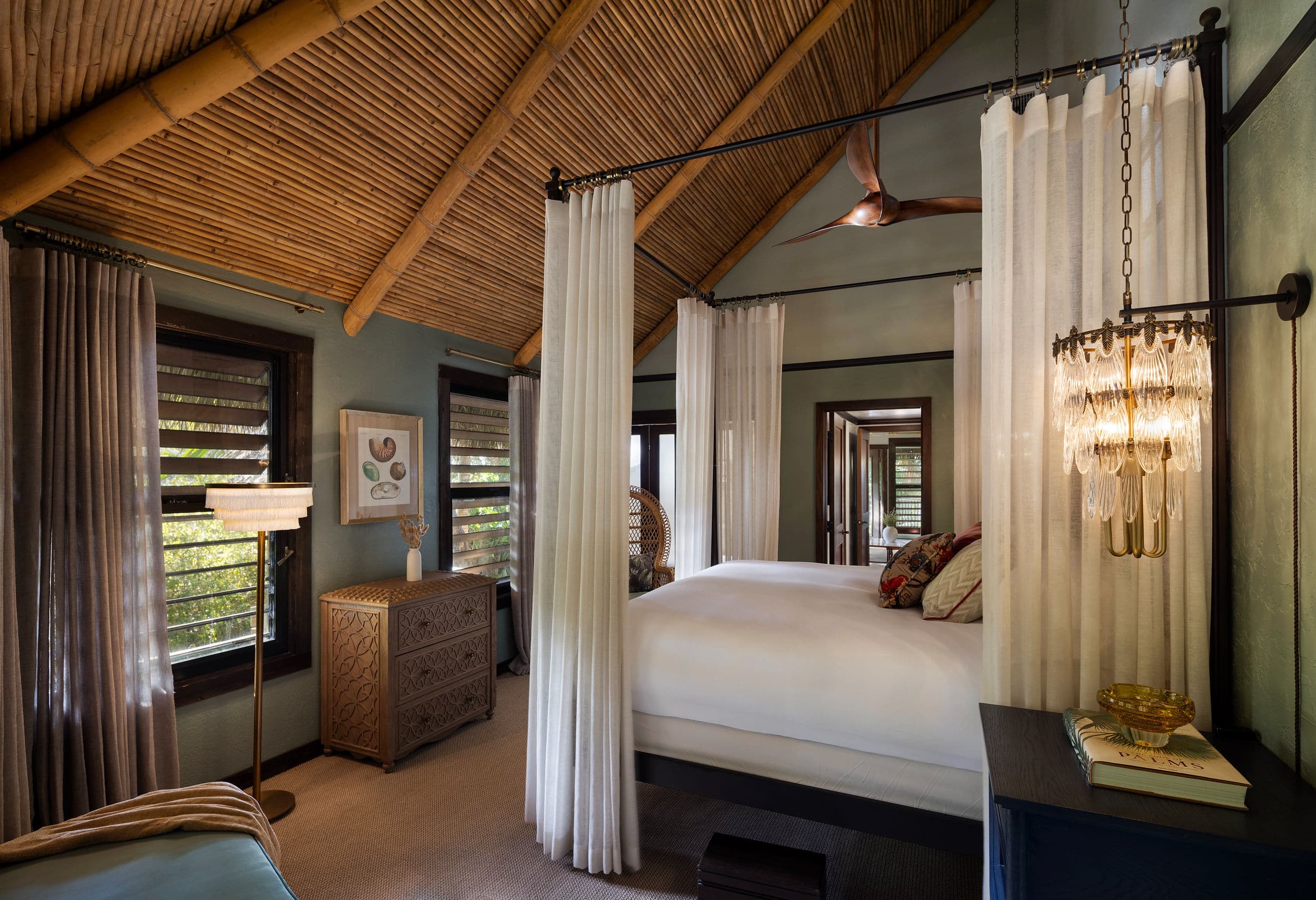 Thatched-roof bungalow suite with a canopy king bed, bamboo ceiling and louvered windows at Little Palm Island Resort & Spa in the Florida Keys