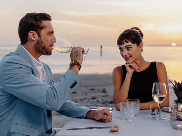 Couple Dining On The Beach.